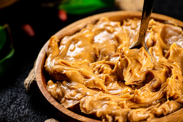 Peanut butter in a wooden plate. 