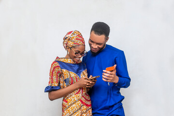 Two black african people holding credit card looking mobile phone
