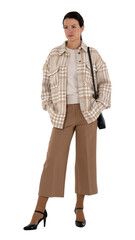 Fototapeta premium Woman in a stylish beige outfit posing with hands in her pockets isolated on white background