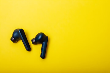 Blue wireless bluetooth earbuds or earphone with charging case on a yellow background. Colors of Ukraine. Possible social concept Hear the other.