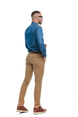 Fototapeta premium full body picture of casual young man walking with hand in pocket