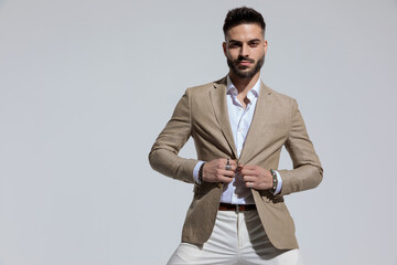 businessman unbuttoning his jacket with attitude