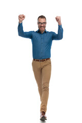 excited young man with fists in the air laughing and celebrating victory