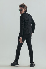 back view of elegant man in tuxedo looking over shoulders
