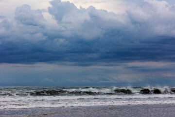 Majestic dramatic sunset sky with large and dark rain clouds in evening time over the Andaman Sea in Langkawi island, Malaysia