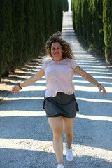 woman running in a way between Tuscany trees