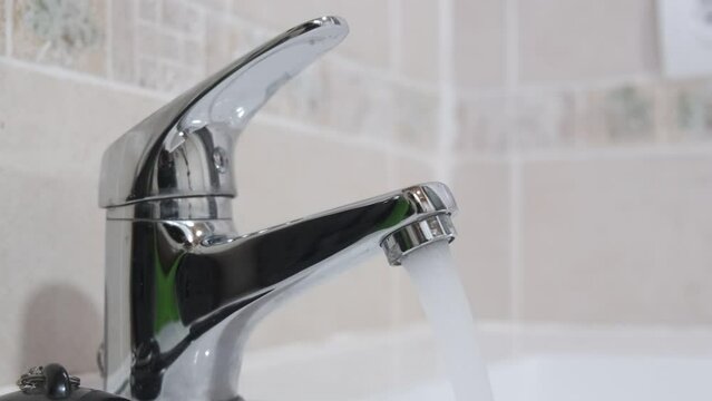 4k v&iacute;deo. Agua del grifo del cuarto de ba&ntilde;o corriendo de forma poco sostenible. Despilfarro de agua
