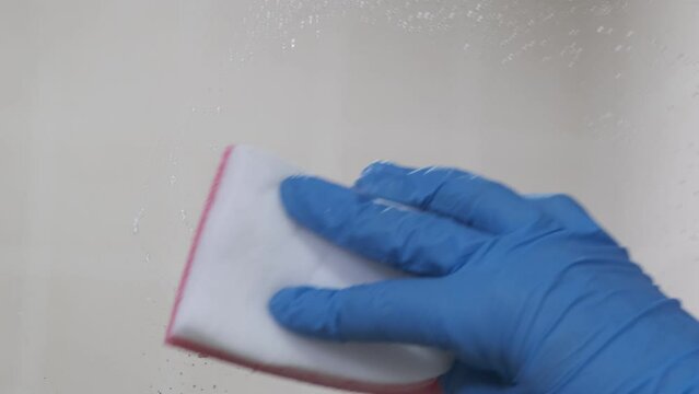 4k v&iacute;deo. Persona limpiando el espejo del cuarto de ba&ntilde;o con jab&oacute;n 