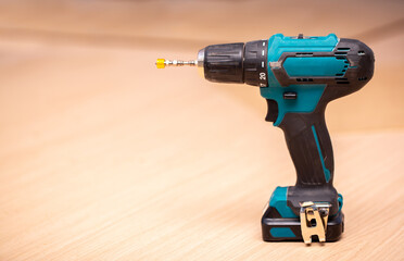 Electric cordless drill driver on the background of a carpentry shop, a professional tool for home...