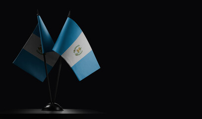 Small national flags of the Guatemala on a black background