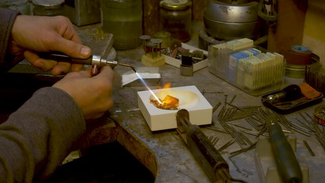 Goldsmith melting a batch of Gold Jewelry into a nugget