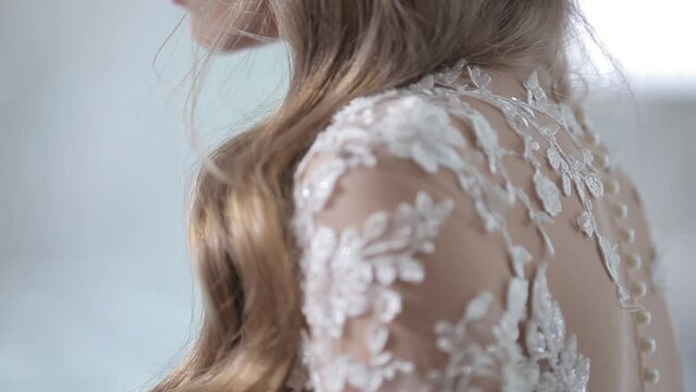 long haired bride in wedding dress shoulders covered with sparkling embroidery on transparent cloth insert close view