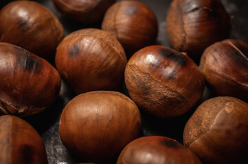 Roasted chestnuts on the background of a dark surface. The species of large plan, close