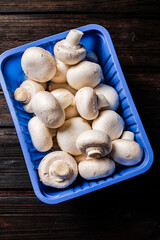 Mushrooms in a plastic box on the table. 