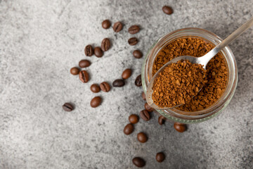Instant coffee and coffee beans on a black stone background. Aromatic coffee drink. Place for text. Space for copy text