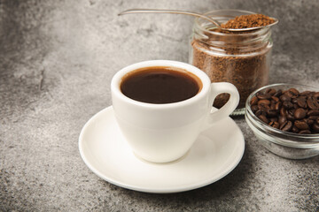 A cup of fragrant espresso coffee, instant coffee and coffee beans on a black stone background. Place for text. Space for copy text