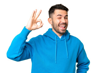 Young handsome caucasian man over isolated chroma key background showing ok sign with fingers