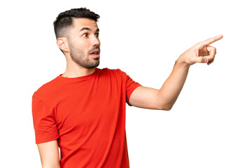 Young handsome caucasian man over isolated chroma key background pointing away