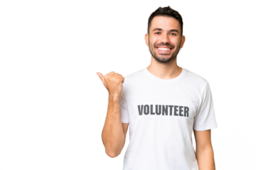Young volunteer caucasian man over isolated chroma key background pointing to the side to present a product