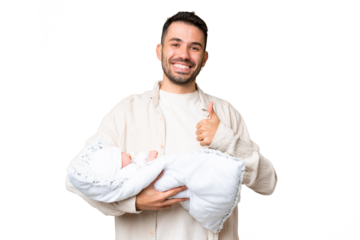 Young caucasian father with her newborn baby over isolated background with thumbs up because something good has happened