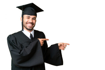 Young university graduate man over isolated chroma key background pointing finger to the side and...