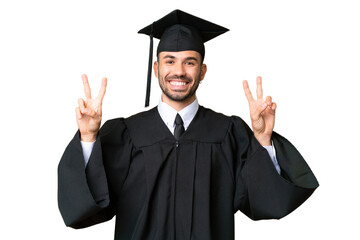 Young university graduate man over isolated chroma key background showing victory sign with both...