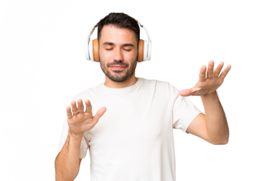 Young caucasian man over isolated chroma key background listening music and dancing