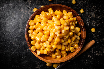 Canned corn on a wooden plate.