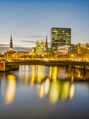 Fototapeta premium Hamburg city buildings and Hauptkirche St. Katharinen tower illuminated at night on Zollkanal, Germany