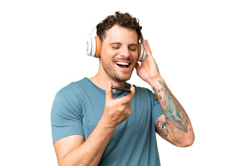 Brazilian man over isolated chroma key background listening music with a mobile and singing