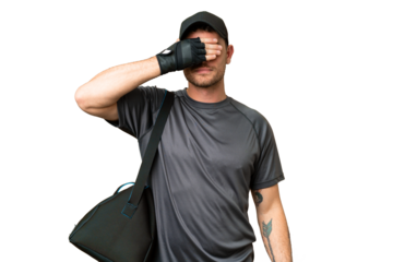 Young sport man with sport bag over isolated chroma key background covering eyes by hands. Do not want to see something