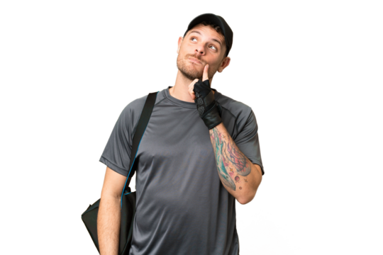 Young sport man with sport bag over isolated chroma key background thinking an idea while looking up