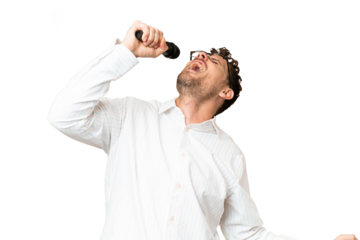 Brazilian man picking up a microphone over isolated chroma key background