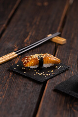 Japanese sushi unagi nigiri sushi smoked eel on wooden background close-up