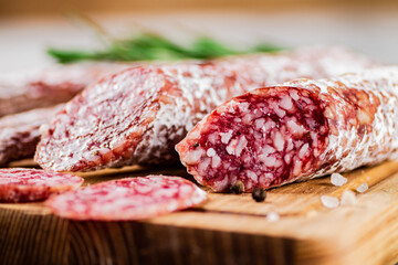 Pieces of salami sausage on a cutting board. 