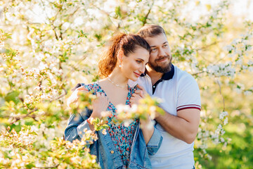 Fototapeta premium a lovers man and a woman in a blooming spring garden. sunlight.