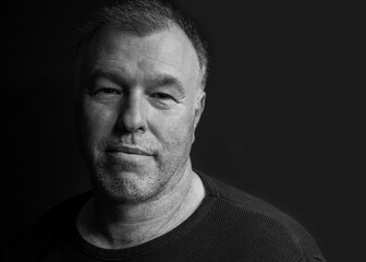 Black and white low key portrait of a  handsome middle-aged man.