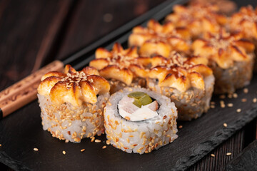 Sushi roll philadelphia with chicken avocado and cream cheese on black background close-up. Sushi menu. Japanese food concept