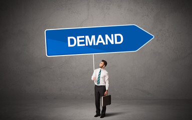 Young business person in casual holding road sign