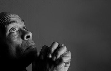 men praying to God with emotion on grey black background with people stock photo