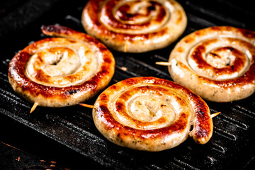 Grilled sausages in a frying pan. 