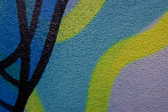 Fragment of the wall with colorful graffiti painting in the street. Part of colorful street art graffiti on wall background