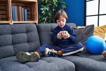Down syndrome kid playing with puzzle cube at home