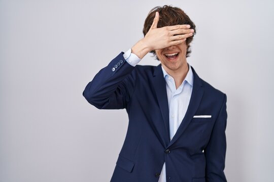 Hispanic business young man wearing glasses smiling and laughing with hand on face covering eyes for surprise. blind concept.