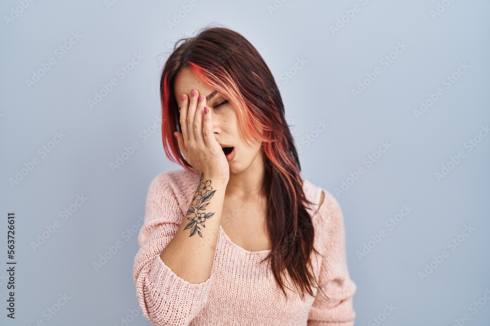 Poster young caucasian woman wearing pink sweater over isolated background yawning tired covering half face