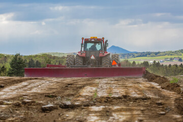 Tractor hauling an Agricultural land leveler on a very cloudy spring day. Farming.  Soil preparation. Agriculture. Agribusiness.  Agricultural machinery. Soil leveler.