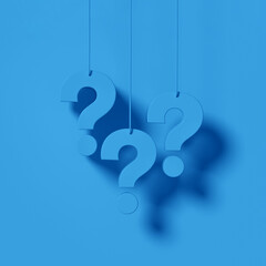 Three blue question marks in front of a blue wall background. FAQ Concept.