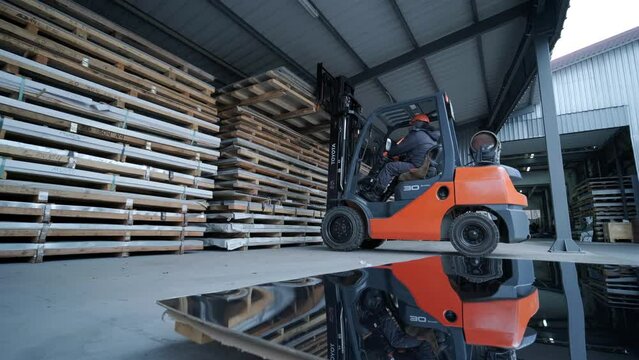 Forklift in a large industrial warehouse of stainless steel. Warehouse for stainless steel