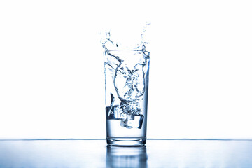 ice cubes splashing into glass water