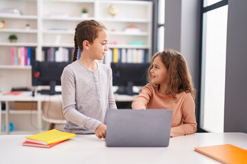 Two kids students using computer studying at classroom